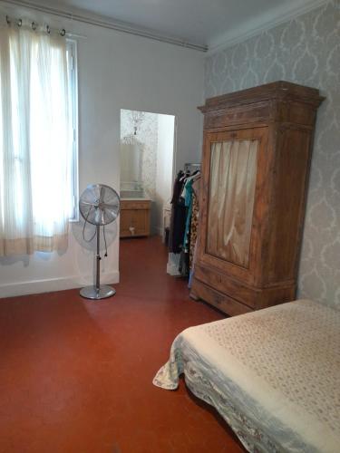 a bedroom with a bed and a dresser and a window at Chambre Palais des Papes Avignon in Avignon