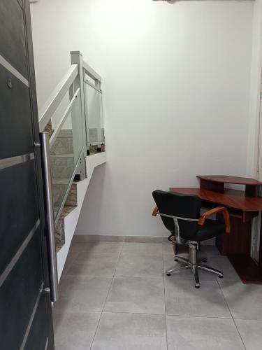 a desk and a chair in a room with a staircase at Concordia, Entre Rios in Concordia