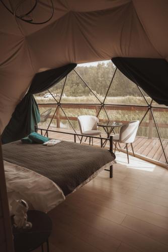 a room with a bed and two chairs in a tent at Глемпінг Zatuшшя in Berezovka