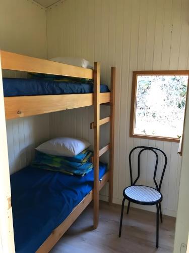 a bunk bed and a chair in a room at Chalet confort 3 piscine partagée in Les Vans