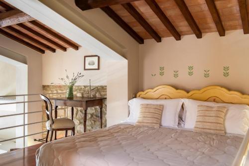 a bedroom with a bed and a table with a chair at Podere Sant'Alessandro in Rapolano Terme
