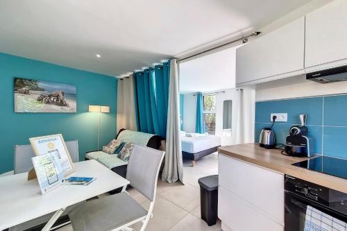 a kitchen and a living room with a table at Aybowan - Jacuzzi - Climatisation in Les Avirons