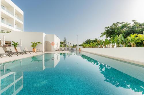 ein Schwimmbad mit blauem Wasser in einem Gebäude in der Unterkunft RH Silene Hotel & Spa 4 Sup in Castellón de la Plana