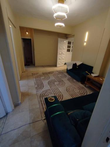 a living room with a couch and a rug at ابراهيم هاوس in Al Ghuşnah