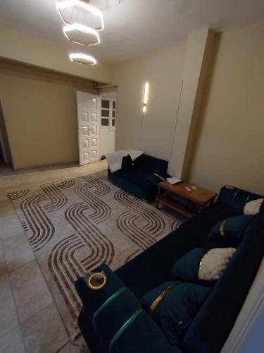 a living room with a couch and a rug at ابراهيم هاوس in Al Ghuşnah