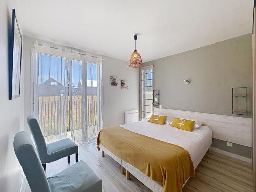 a bedroom with a bed and a chair and a window at Les Gîtes du Pêcheur in Erquy