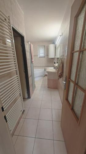 a bathroom with a toilet and a tub and a sink at La Flower Nesvady in Nesvady