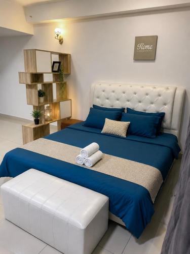 a bedroom with a large bed with blue sheets and blue pillows at Crystal Studio Apartment D'Perdana in Kota Bharu