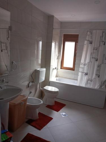 ein Badezimmer mit Badewanne, Toilette und Waschbecken in der Unterkunft Bane apt in Kravlja