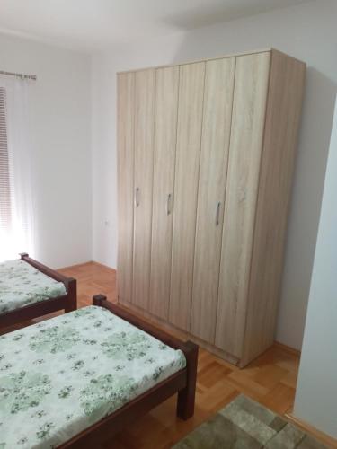 ein Schlafzimmer mit zwei Betten und einem Holzschrank in der Unterkunft Bane apt in Kravlja