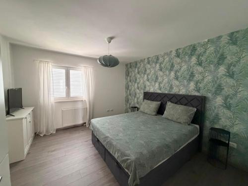 a bedroom with a bed with a green patterned wall at Holiday home " MIA" in Gradina