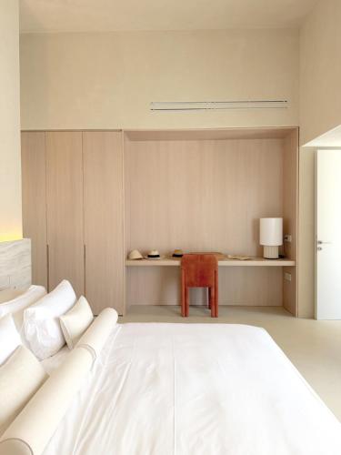 a bedroom with a white bed and a desk at VOUNO Santorini Private Villas in Pyrgos
