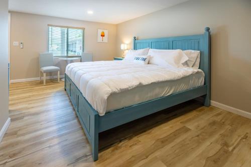 a bed with a blue frame in a bedroom at Blue Lobster Inn Cape Cod in Yarmouth
