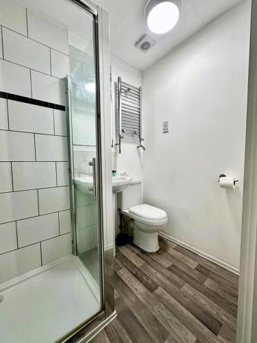 a bathroom with a toilet and a glass shower at Trivelles Liverpool in Liverpool