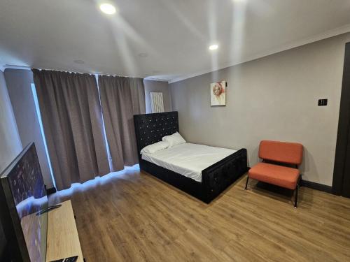 a small bedroom with a bed and a chair at Prime's Home in Nevendon