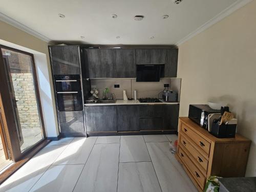 a kitchen with wooden cabinets and a counter top at Prime's Home in Nevendon