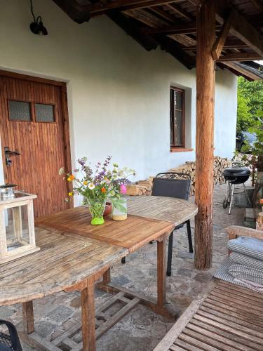 a wooden table with a vase of flowers on it at Apartmány pod Kozákem in Velké Popovice