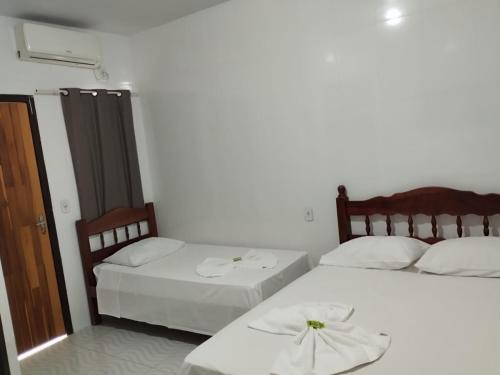 two beds in a room with white walls at Delta Hotel Nova Mutum in Nova Mutum