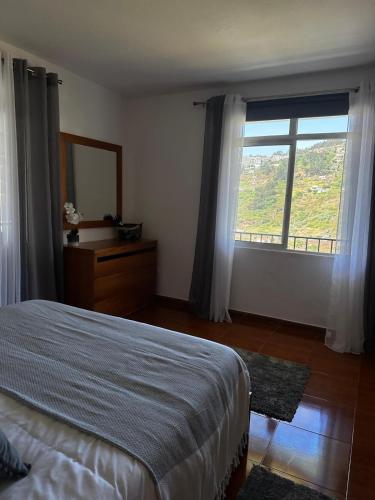 a bedroom with a bed and a large window at Alojamento Local - El Paraiso in Câmara de Lobos