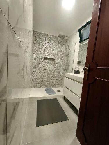 a bathroom with a shower with a glass door at Alojamento Local - El Paraiso in Câmara de Lobos