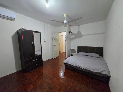 a bedroom with a bed and a dresser and a mirror at AymanSyahir in Mukah