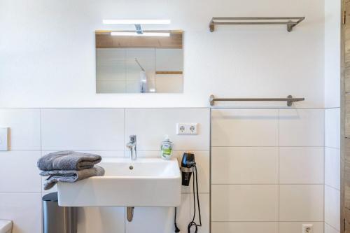 a white bathroom with a sink and a shower at Hubertus in Dietingen