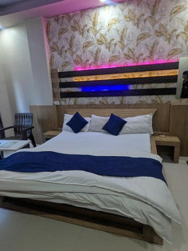 a bedroom with a large bed with a wall at Hotel MJ in Ujjain