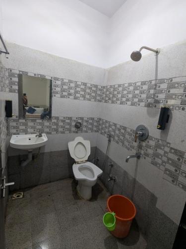 a bathroom with a toilet and a sink at Hotel MJ in Ujjain