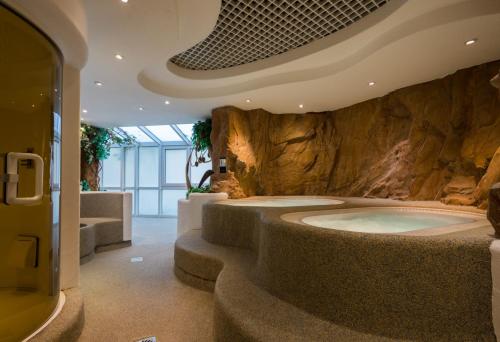 a large bathroom with a tub in a stone wall at Hotel Fortuna in Schwäbisch Gmünd