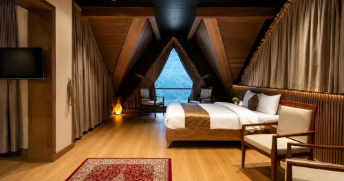a bedroom with a bed and a large window at Serene Resorts Naran in Naran