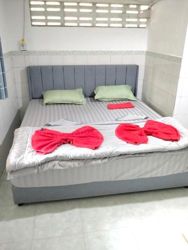 a bed with two red dresses on top of it at Home Frog Guesthouse in Phnom Penh