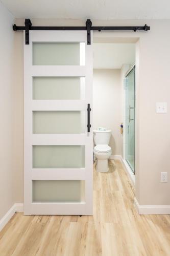 a sliding barn door in a bathroom with a toilet at Blue Lobster Inn Cape Cod in Yarmouth