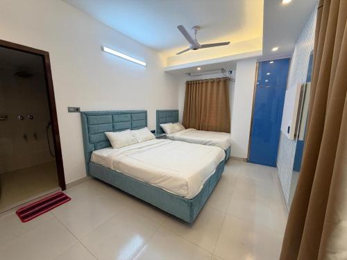 a bedroom with two beds and a ceiling fan at Hotel Moon Light in Dhaka