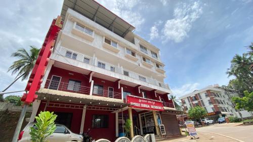a red and white building on a city street at Sri Durga Residency in Subrahmanya