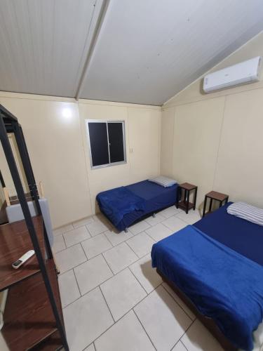 a room with two beds and a tv in it at Condomínio Gold in Três Lagoas