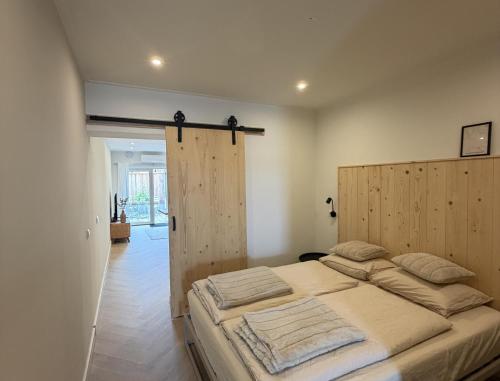 a bedroom with a large bed with a wooden headboard at Herberg de Smederij in Kampen