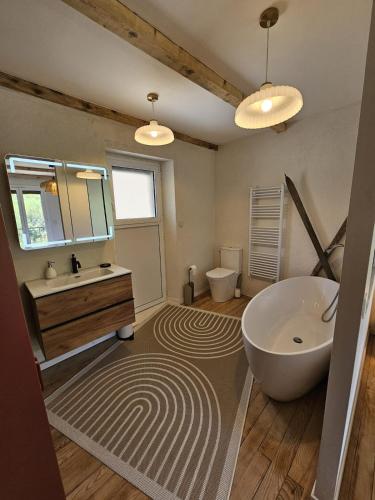a bathroom with a tub and a sink and a mirror at La Parenthèse Enchantée Chalet in Beuil