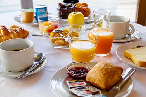 una mesa cubierta con platos de comida y bebidas para el desayuno en Nina, en Carcassonne