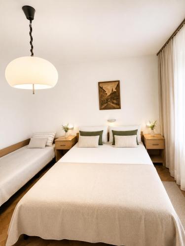 a bedroom with two beds and a chandelier at Apartmani Selce za 2-3 osobe in Selce