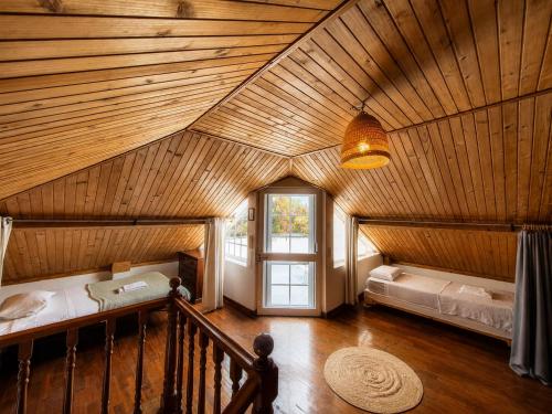 an attic room with two beds and a window at Jaca Hostel Porto da Cruz in Porto da Cruz