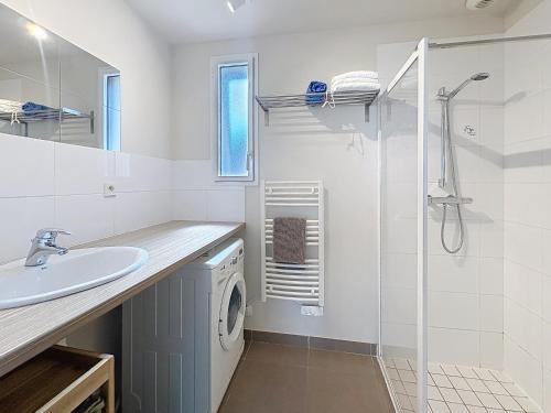 a bathroom with a sink and a washing machine at Les Gîtes du Pêcheur in Erquy