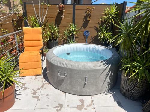 a large circular hot tub in a yard with plants at SETE BELLE MAISON DE VILLE 121 m2 A 2 mn DE LA PLAGE et SPA in Sète