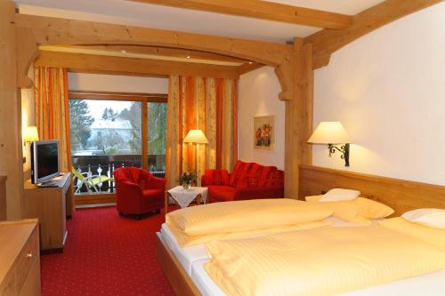 バート・ヴェーリスホーフェンにあるKurhotel Eichingerのベッドとテレビが備わるホテルルームです。