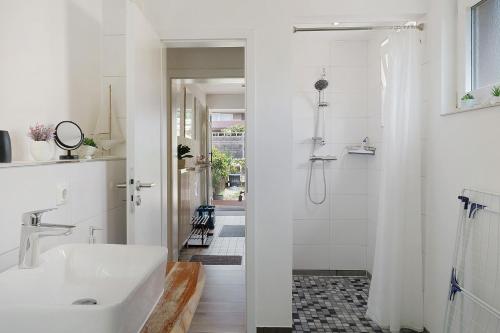 a white bathroom with a sink and a shower at Lärche in Sprakensehl