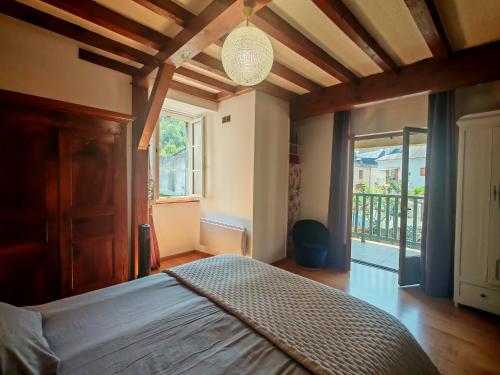 a bedroom with a bed and a large window at Le Pène de Béon in Aste-Béon