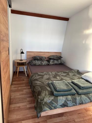 a bedroom with a bed and a side table at Noclegi nad jeziorem in Wiartel Mały