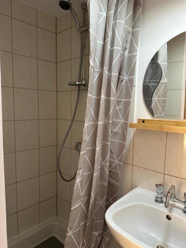 a bathroom with a shower curtain and a sink at Noclegi nad jeziorem in Wiartel Mały