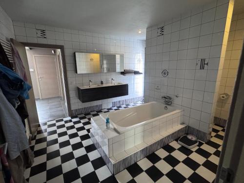 a bathroom with a tub and a checkered floor at logies 2460 in Kasterlee