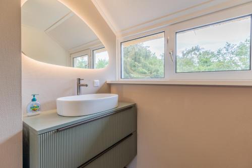a bathroom with a sink and two windows at Stille Wille in Ballum