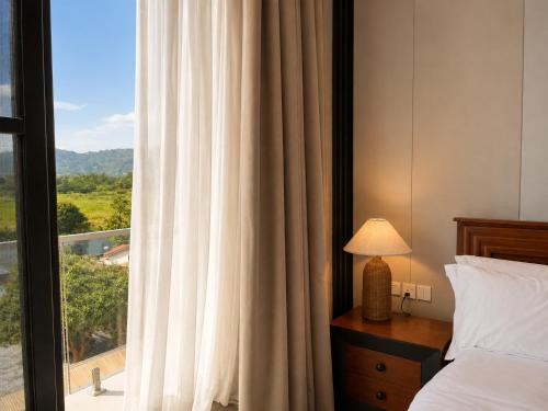 a hotel room with a bed and a window at Mia Bella Madre Morogoro in Morogoro